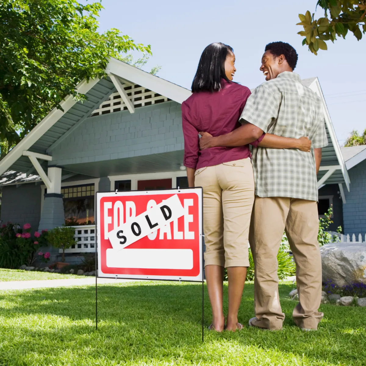 Couple in front of their sold home in Summit County, Ohio